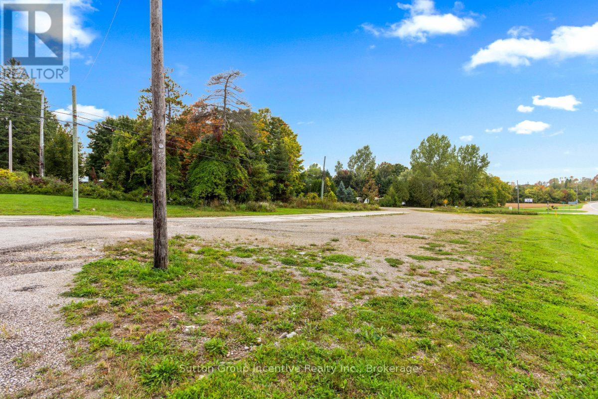 A grassy field with a telephone pole in the foreground and trees in the background.