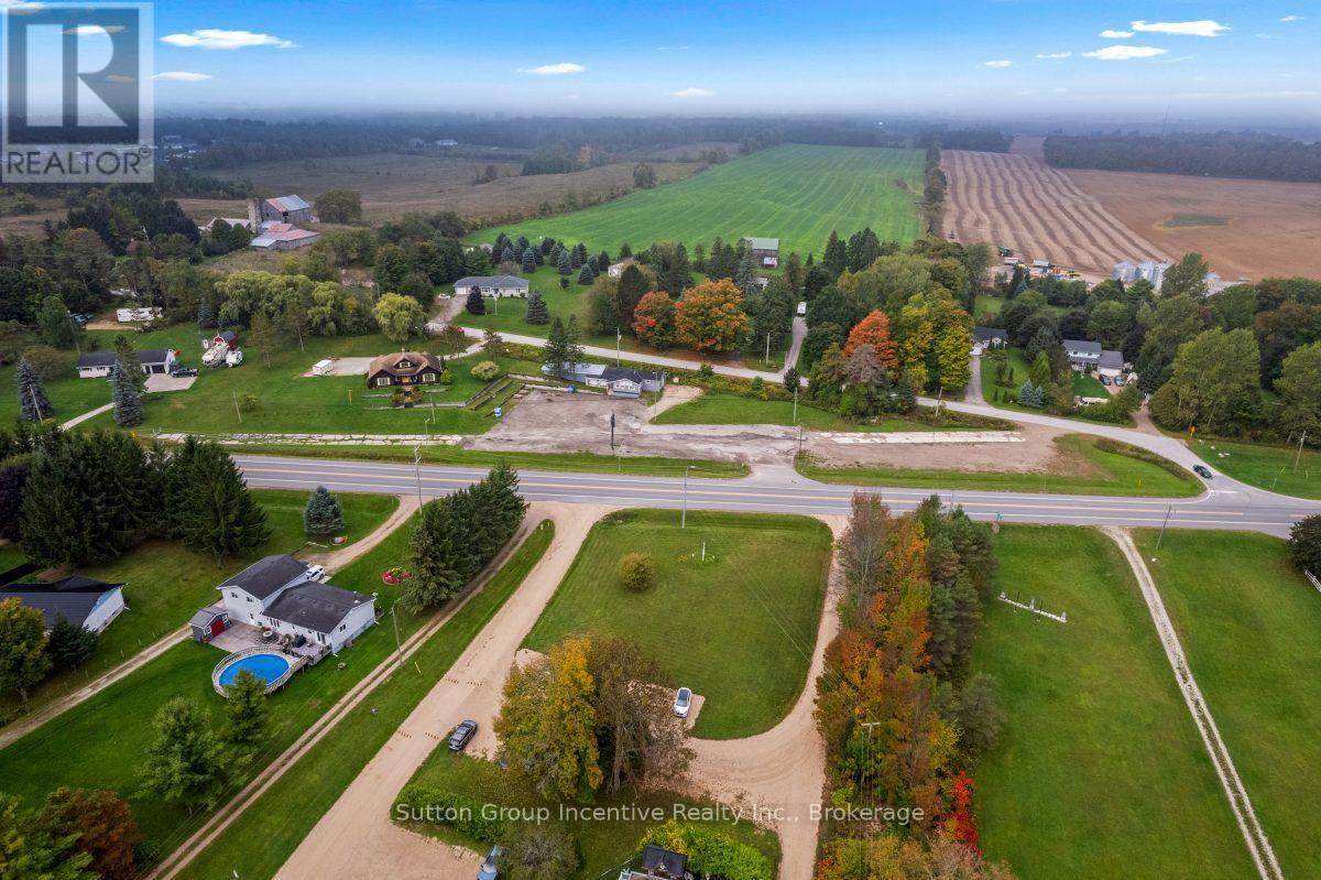 An aerial view of a residential area with a large open field in the background.