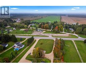 An aerial view of a residential area with a large open field in the background.