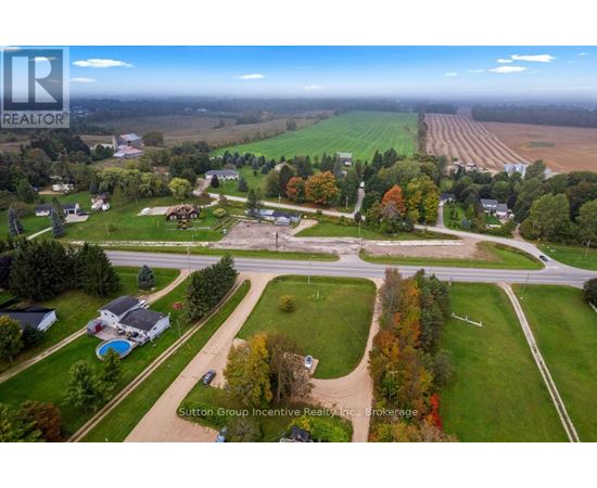 An aerial view of a residential area with a large open field in the background.