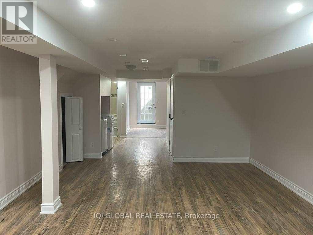 A long hallway with wood floors and white walls.