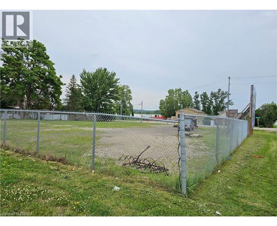 A chain link fence surrounds a dirt field.