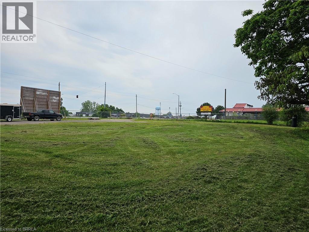 A grassy field with a truck and a building in the distance.