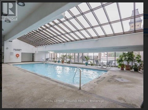 A pool inside a building with a glass ceiling.