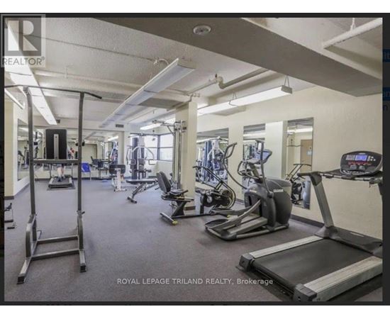 A gym with a variety of equipment including treadmills, weights, and exercise machines.
