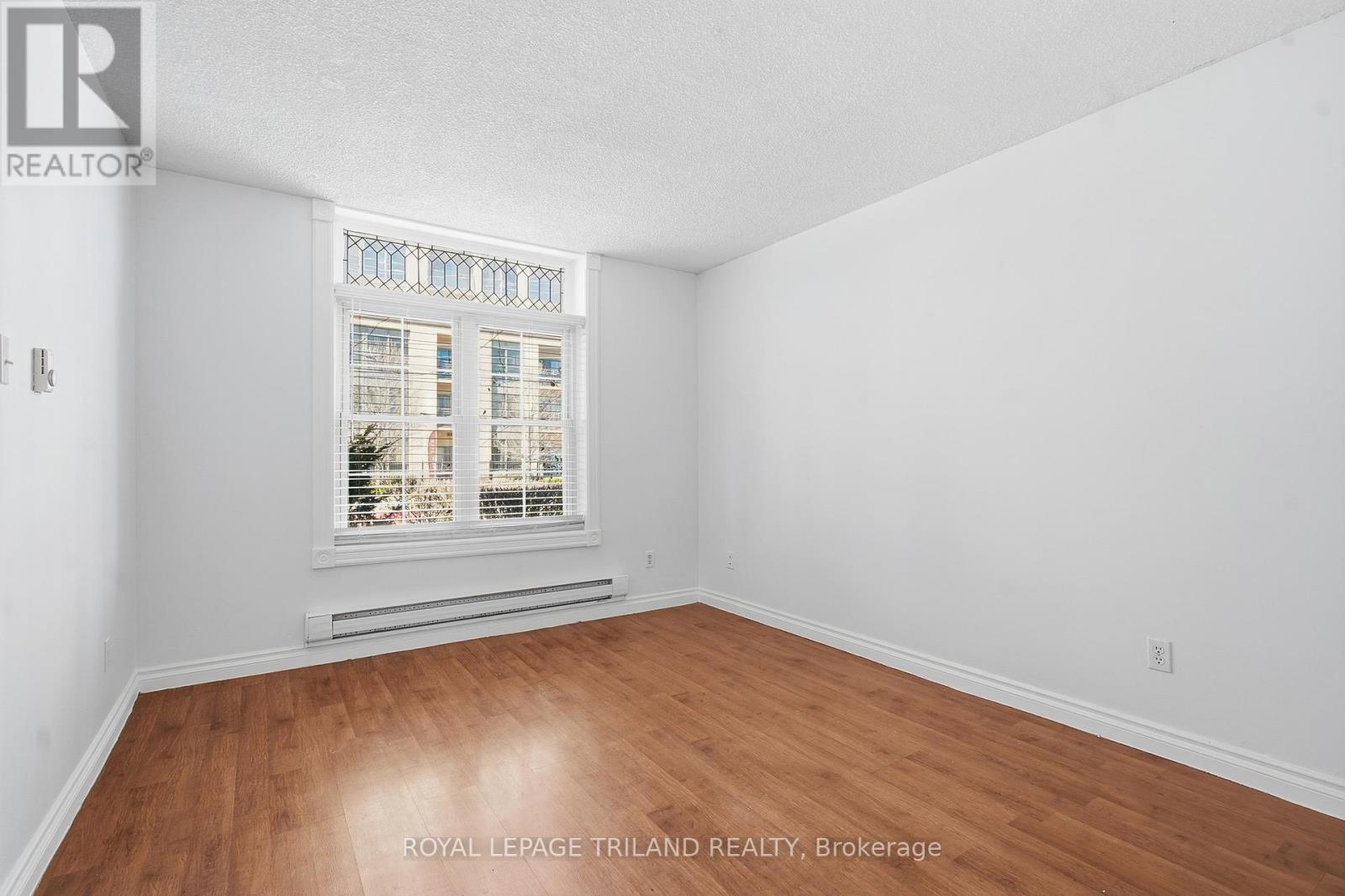 A room with a window and wooden flooring.