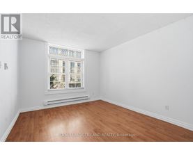 A room with a window and wooden flooring.