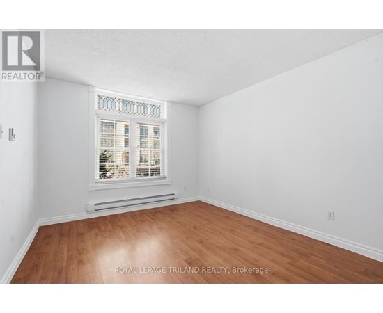 A room with a window and wooden flooring.