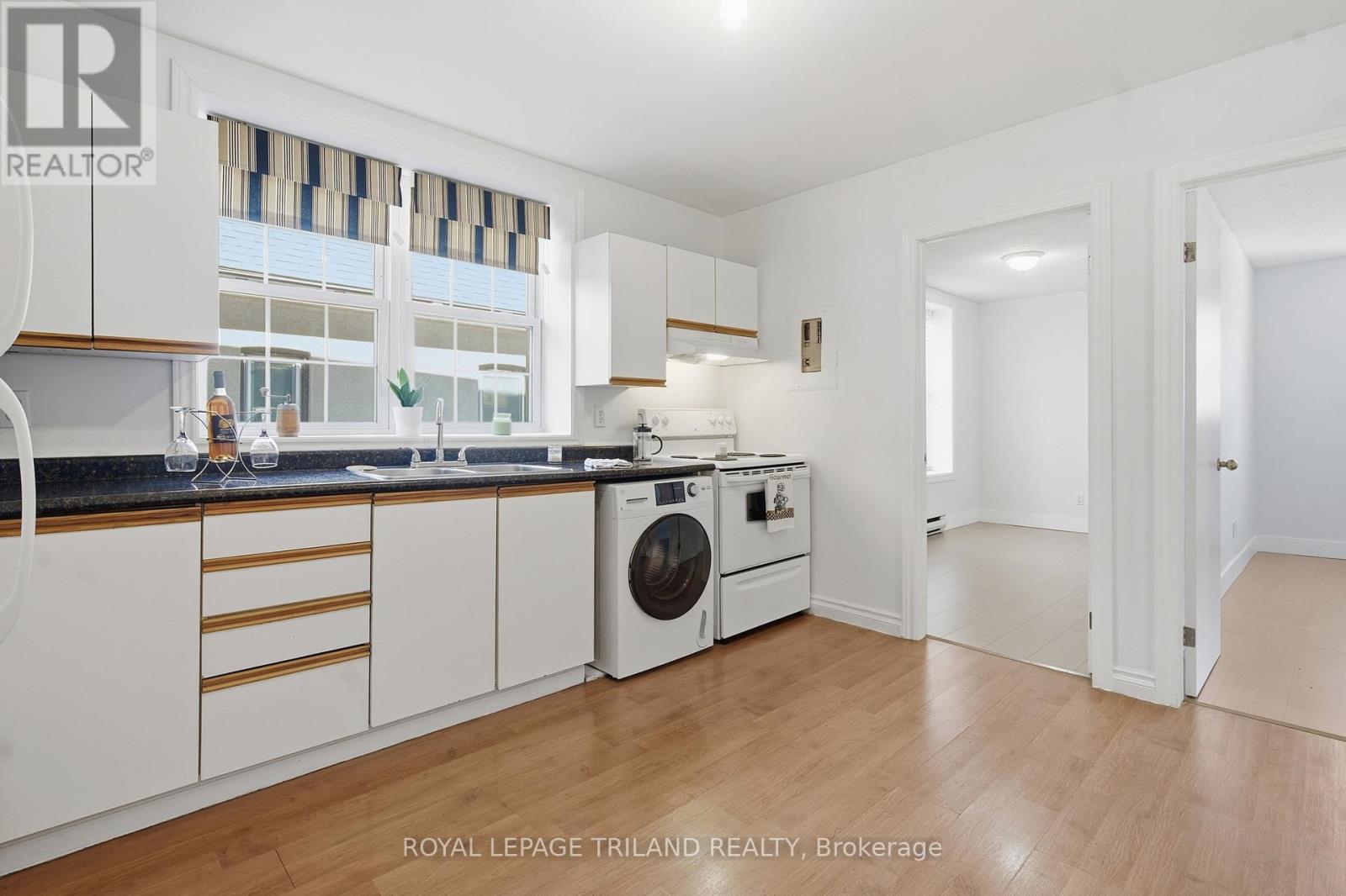 A white kitchen with a washing machine and a dishwasher.