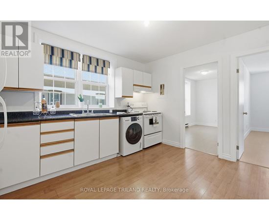 A white kitchen with a washing machine and a dishwasher.