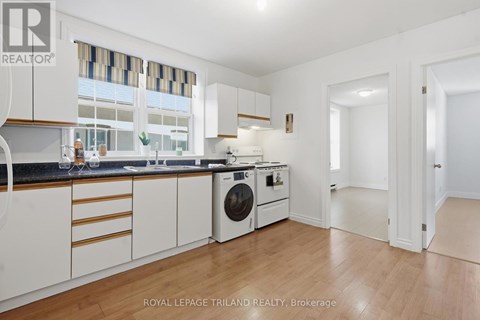 A white kitchen with a washing machine and a dishwasher.