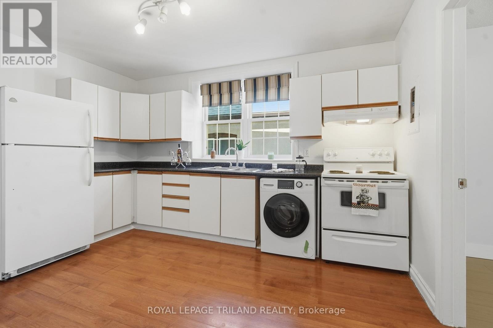 A white kitchen with a washing machine and a dishwasher.