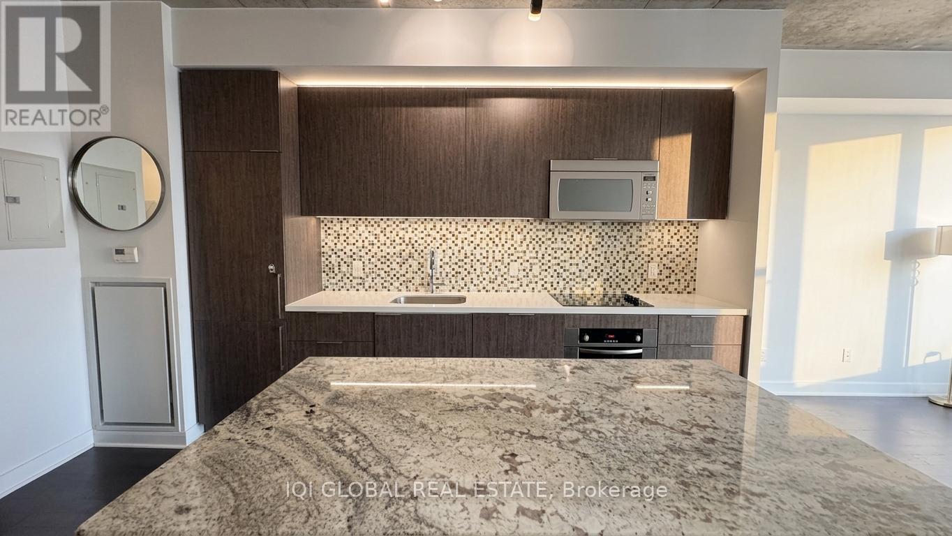A bedroom with a large bed and a flat screen TV mounted above a cabinet.
