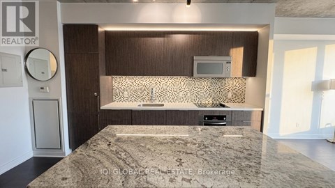 A bedroom with a large bed and a flat screen TV mounted above a cabinet.