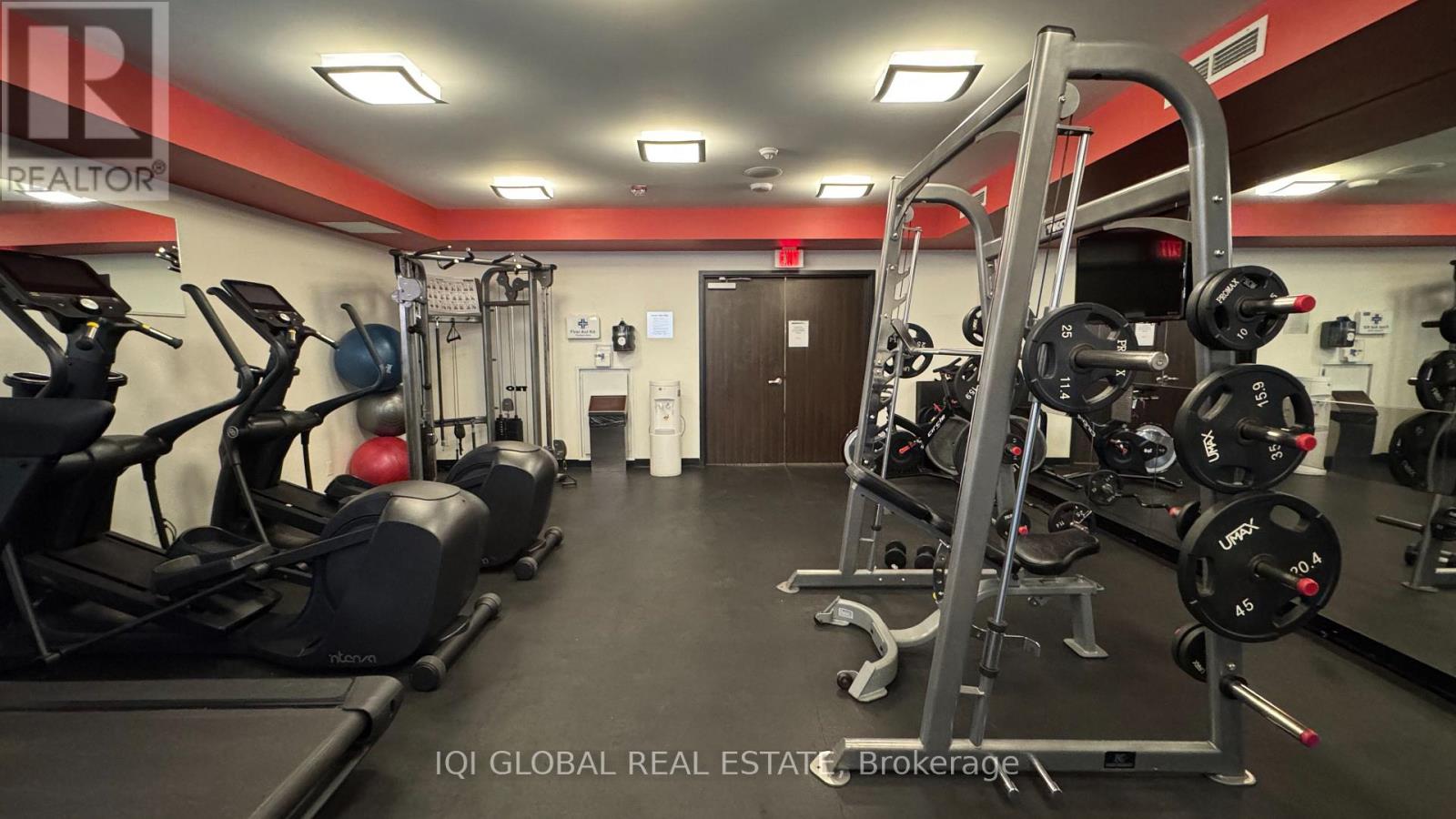 A gym with a variety of equipment including treadmills, weights, and exercise machines.