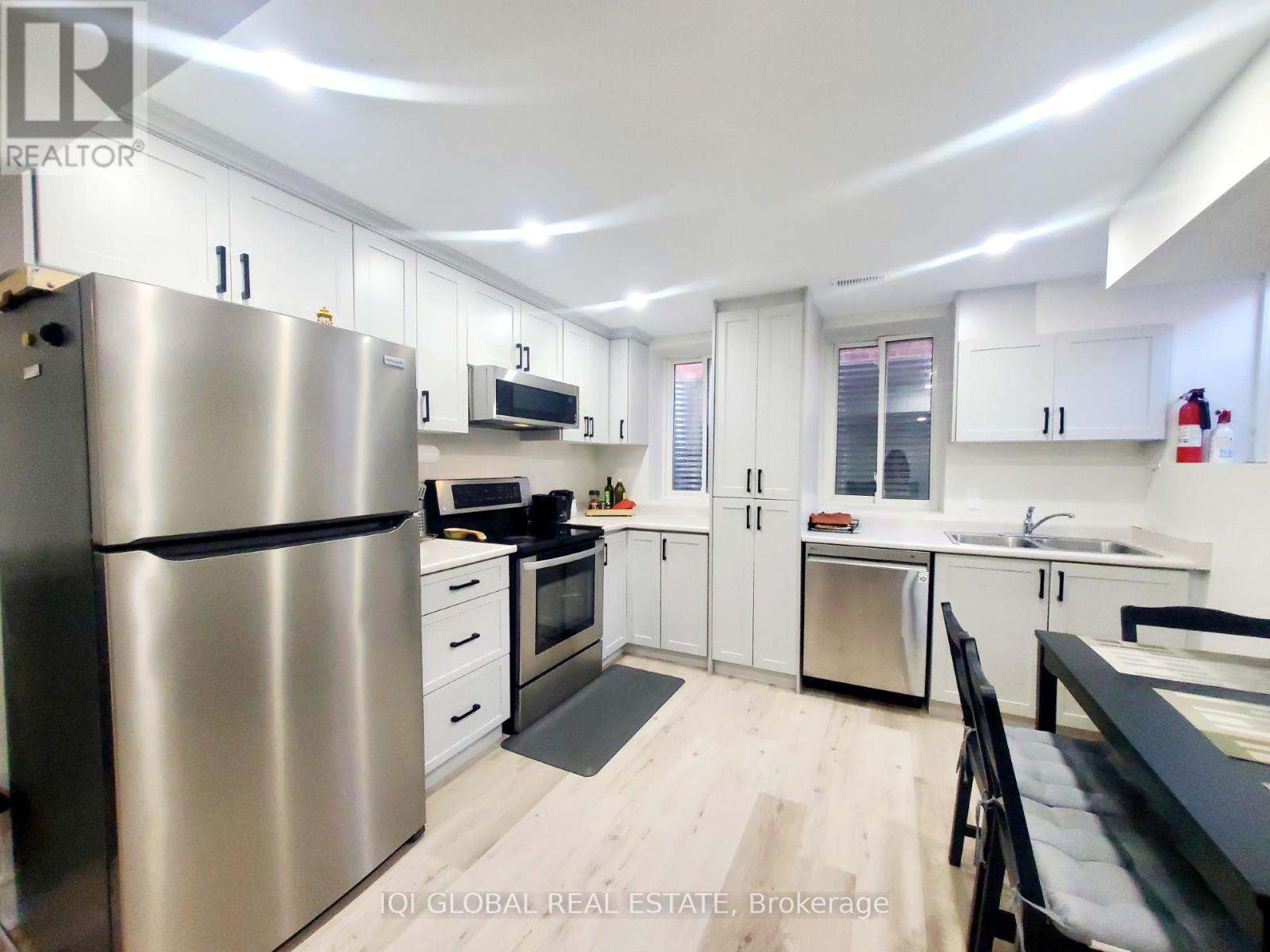 A modern kitchen with stainless steel appliances and white cabinets.