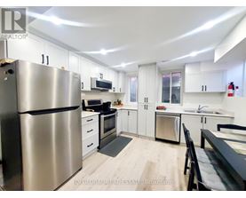 A modern kitchen with stainless steel appliances and white cabinets.