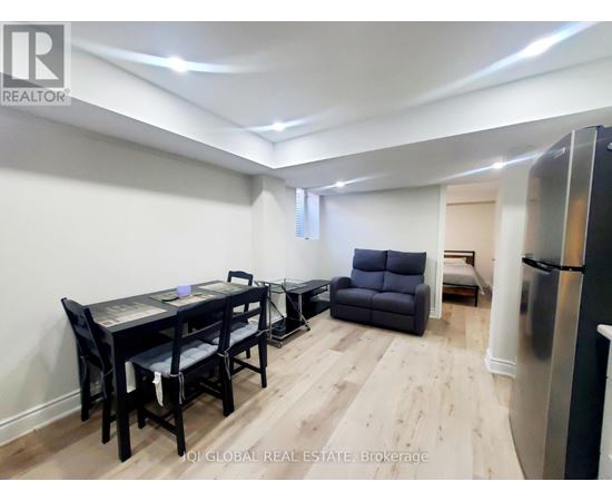 A dining room with a table and chairs.