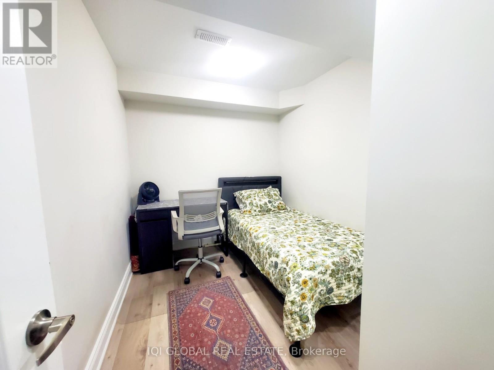A small bedroom with a bed, desk, and chair.