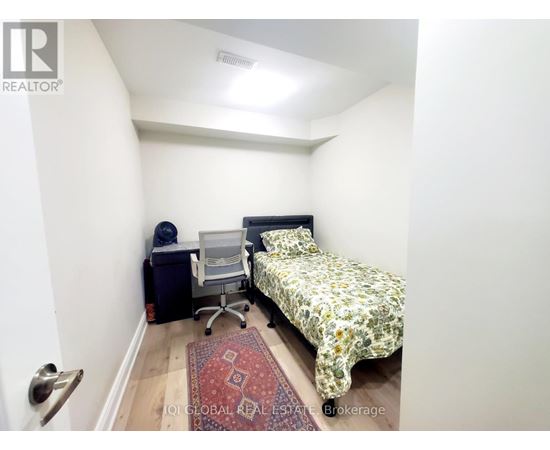 A small bedroom with a bed, desk, and chair.