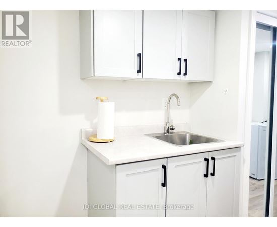 A white kitchen with a sink and cabinets.