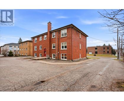 A large red brick building with a parking lot in front.