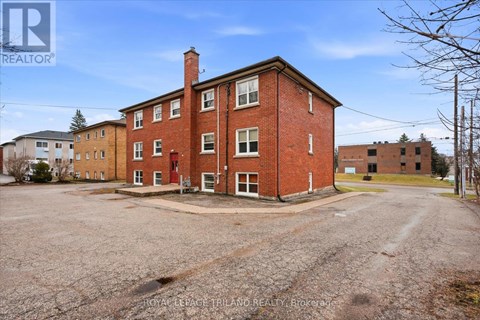 A large red brick building with a parking lot in front.