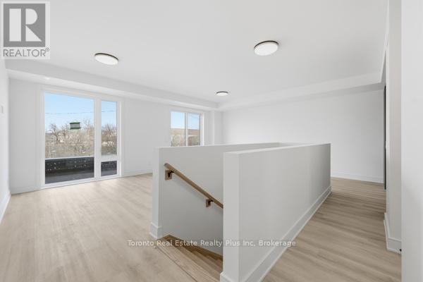A spacious room with a wooden floor and white walls, with a window showing a view of a snowy landscape.