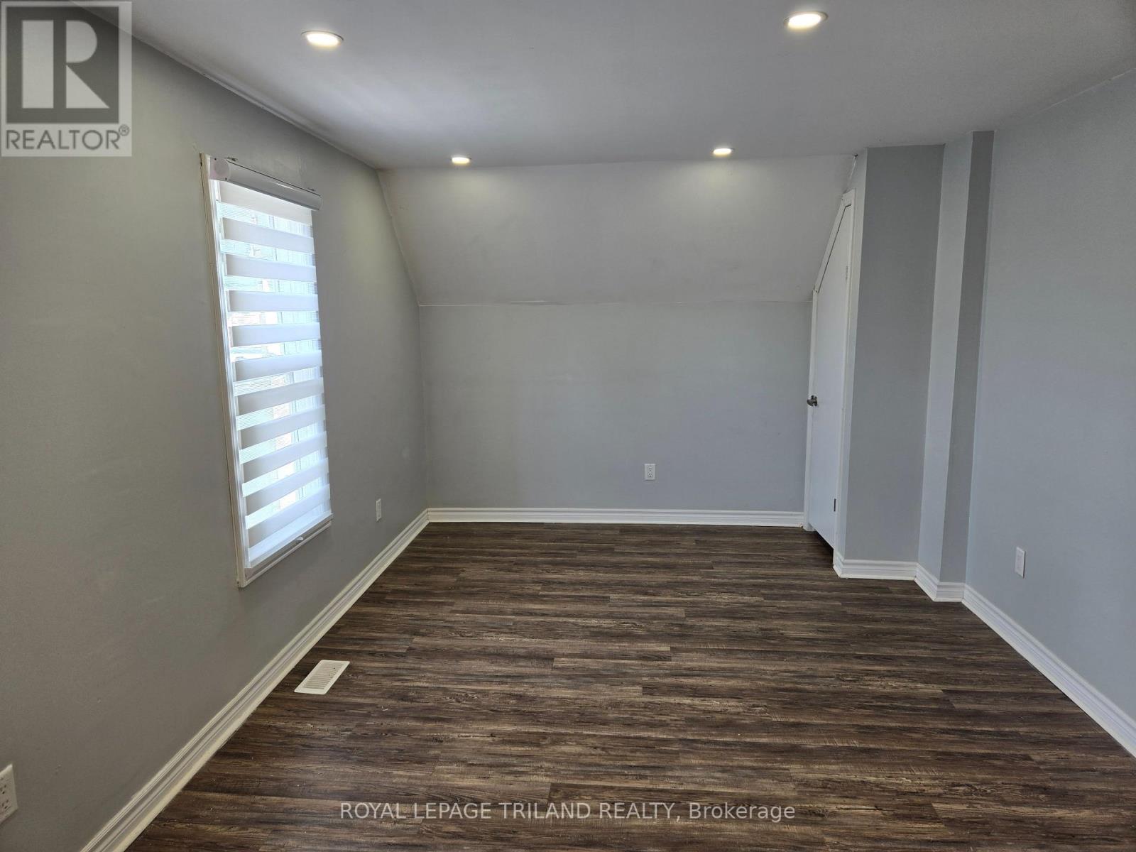 A room with wooden flooring and white walls.