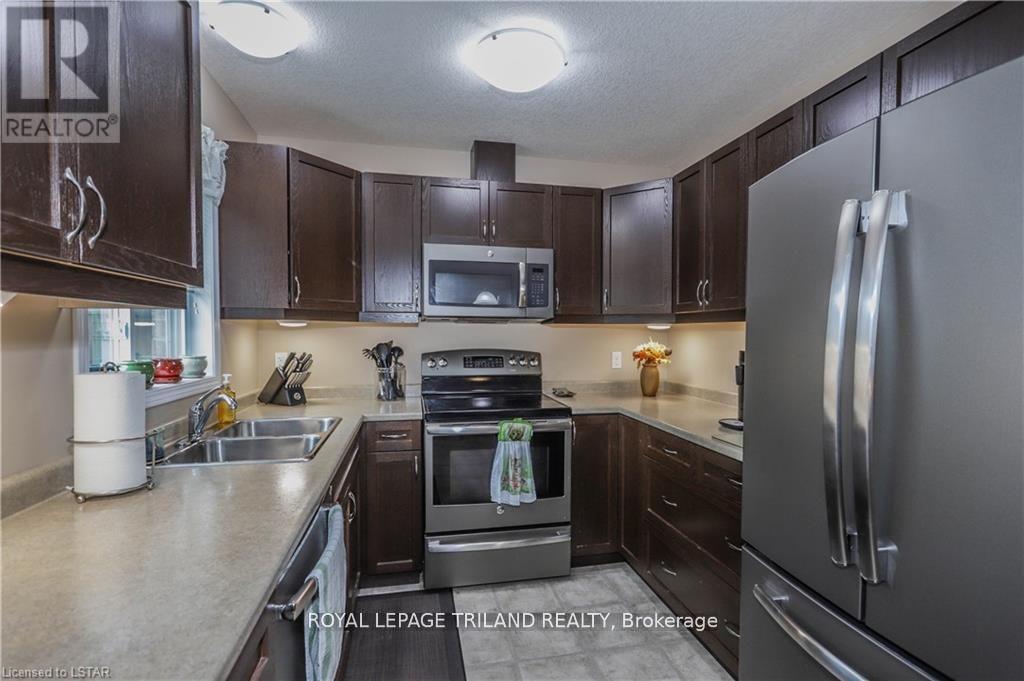 A kitchen with brown cabinets and a stainless steel refrigerator.
