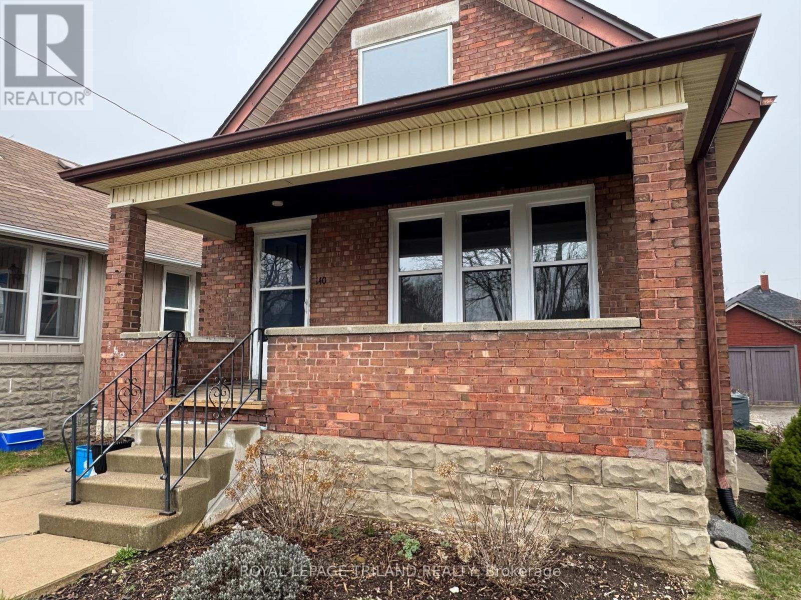 A brick house with a small front yard.