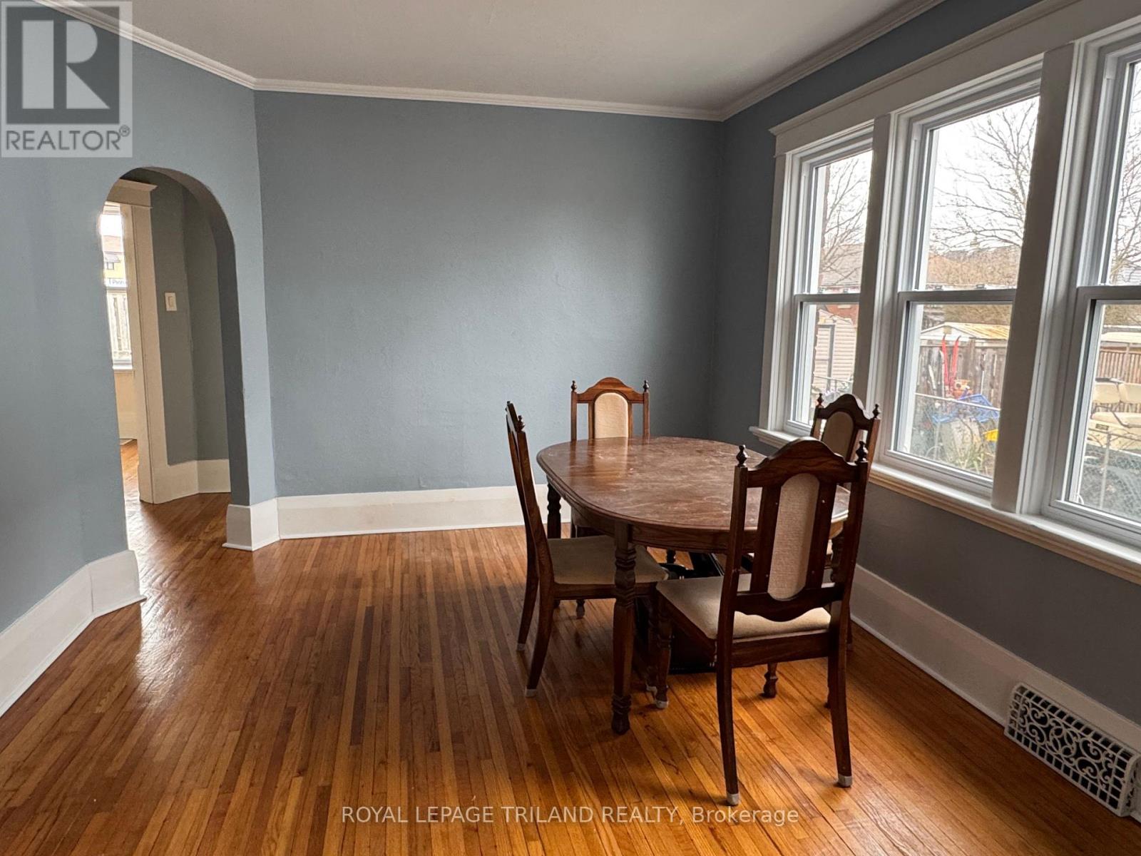 A dining room with a wooden table and chairs.