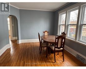 A dining room with a wooden table and chairs.