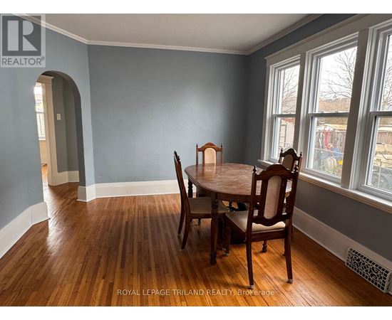 A dining room with a wooden table and chairs.