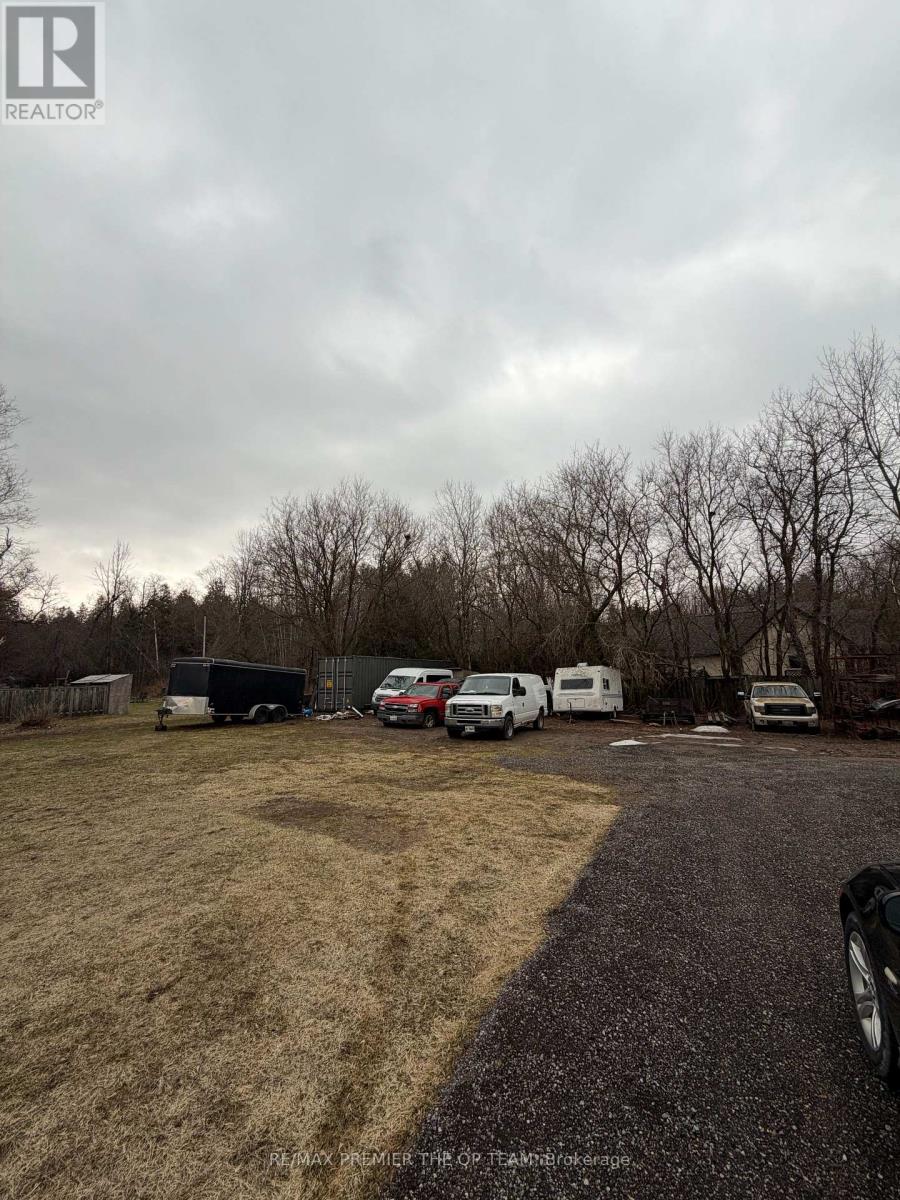 A realtor image of a property with a parking lot and vehicles.