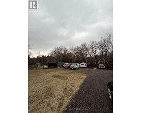 A realtor image of a property with a parking lot and vehicles.