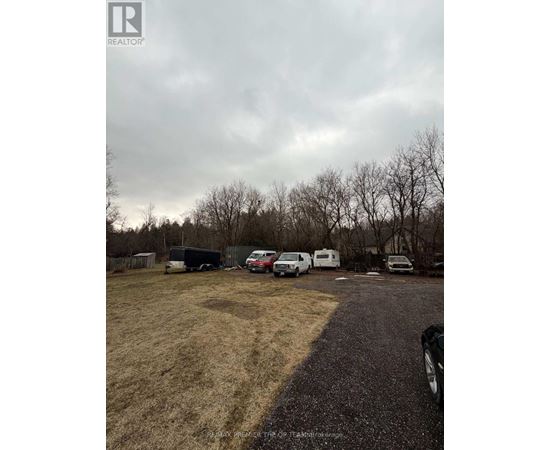 A realtor image of a property with a parking lot and vehicles.