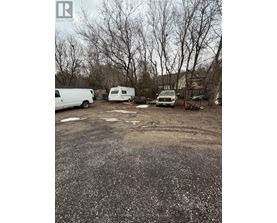 A gravel lot with a white van, a white trailer, and a white truck.