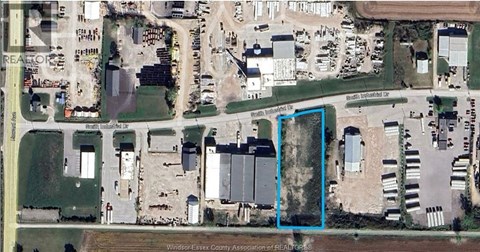 A satellite image shows a large building complex with a parking lot in front.