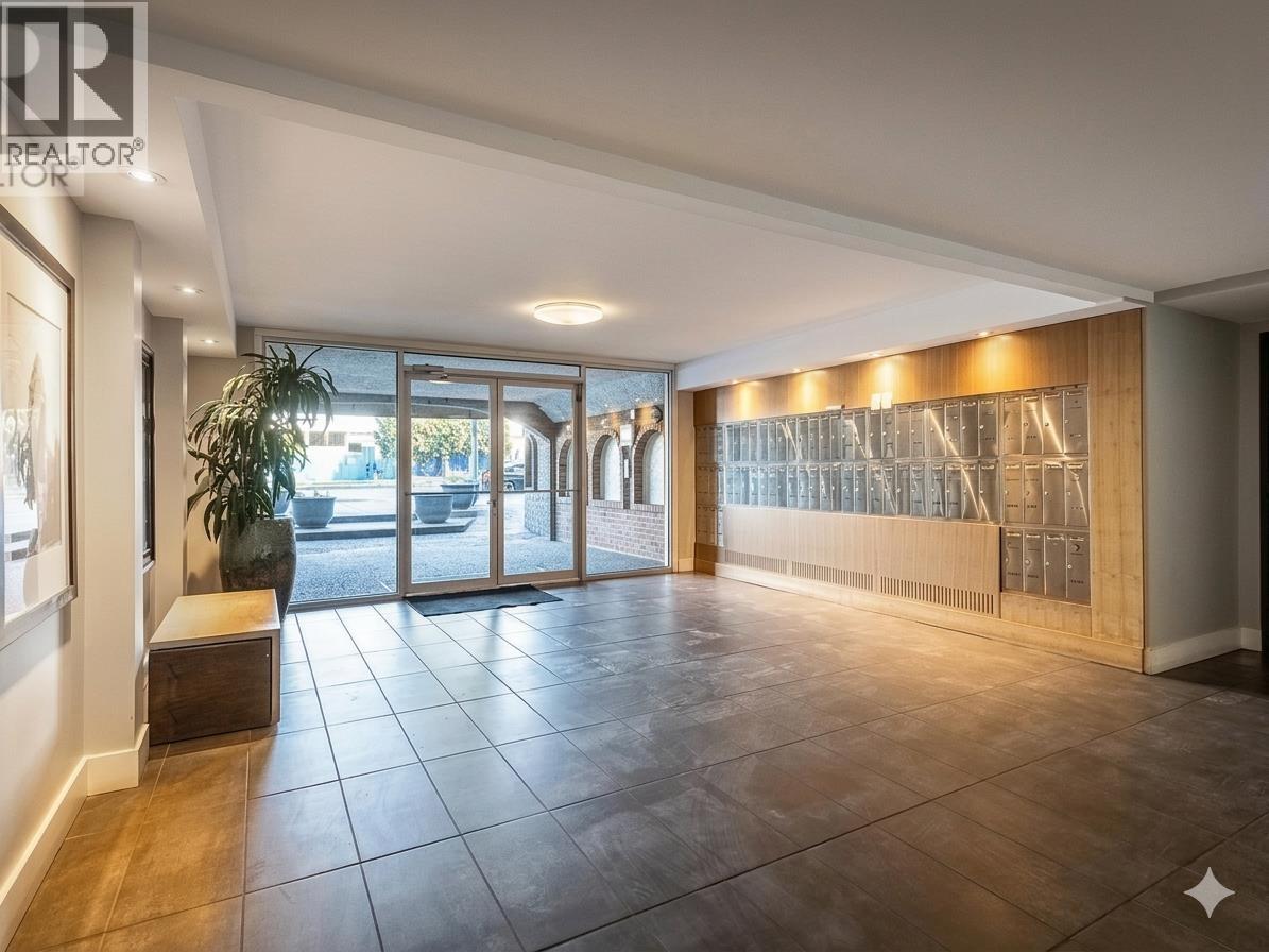 A spacious room with a large window and a wooden panel on the wall.