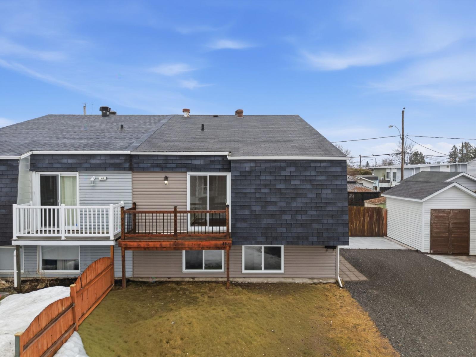 A house with a grey roof and a brown fence.