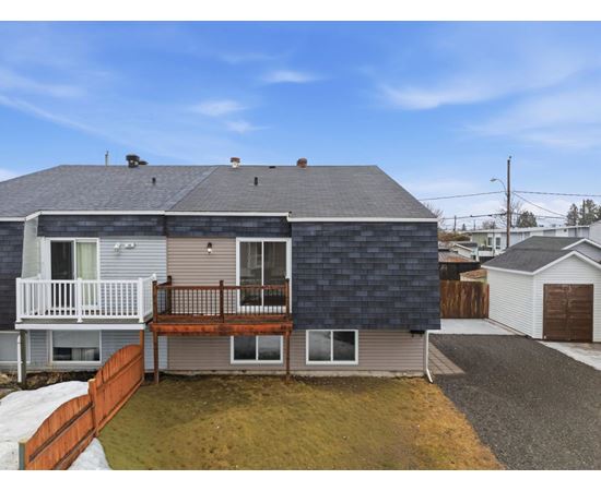A house with a grey roof and a brown fence.