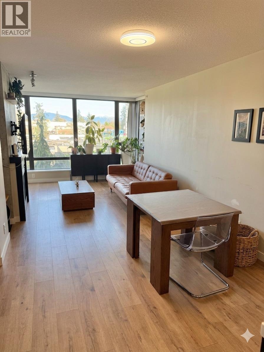 A living room with a couch, coffee table, and a large window.