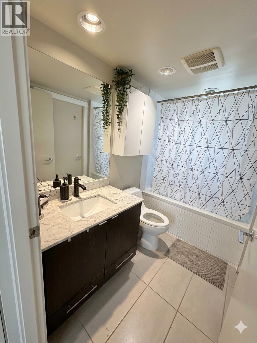 A bathroom with a toilet, sink, and shower curtain.