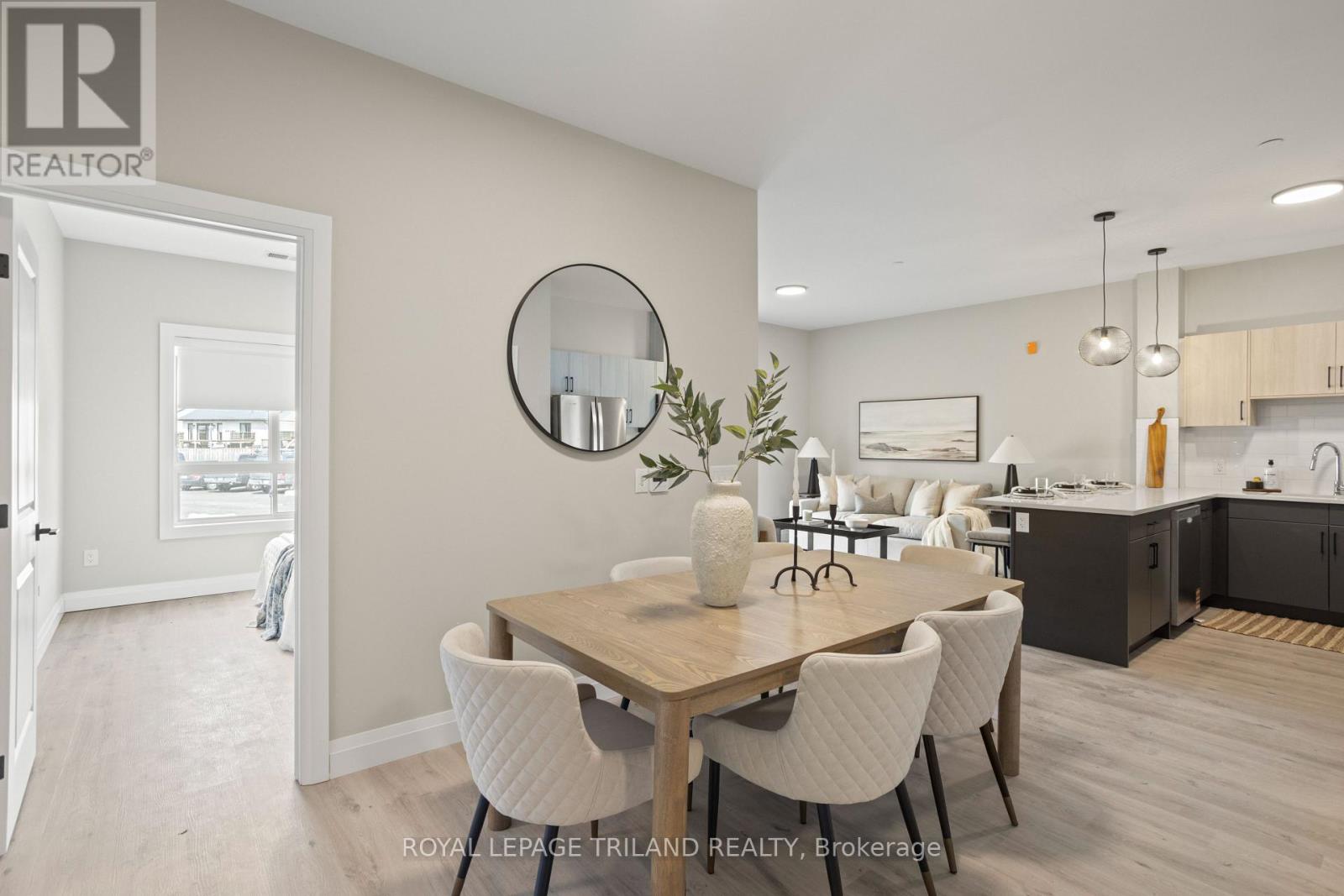 A dining room with a wooden table and white chairs.