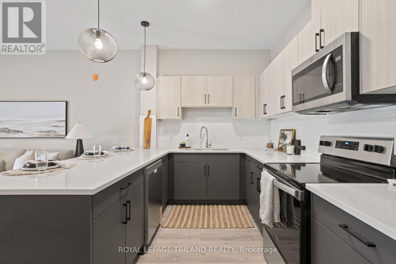 A modern kitchen with a white countertop and black cabinets.