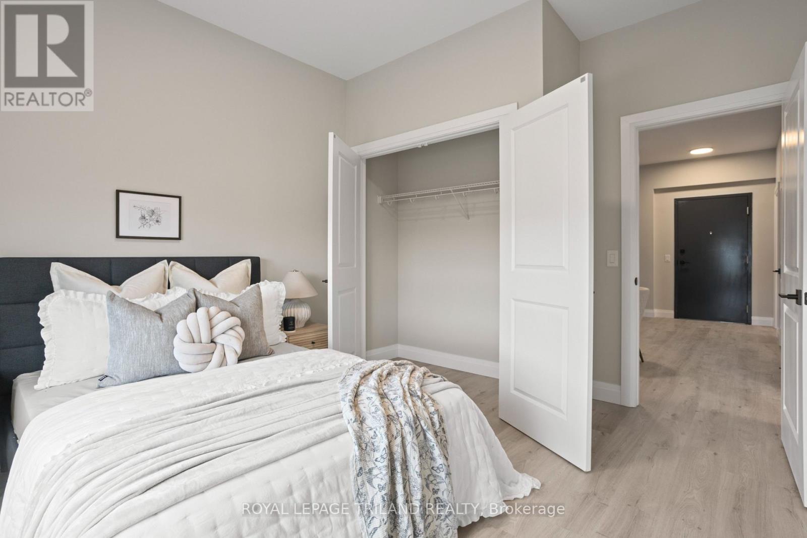 A bedroom with a large bed and a white door.