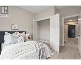A bedroom with a large bed and a white door.