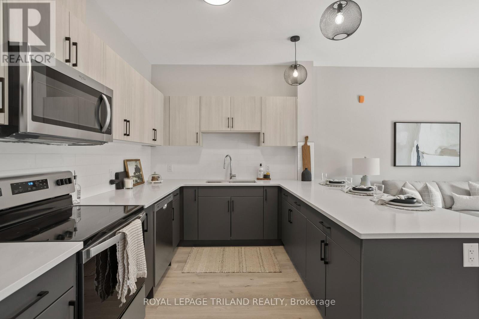 A modern kitchen with a white countertop and dark cabinets.