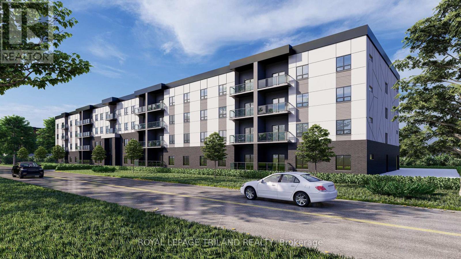 A modern apartment building with cars parked in front.
